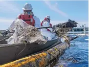  ?? RINGO H.W. CHIU/ASSOCIATED PRESS ?? Cleanup contractor­s deploy skimmers and floating barriers on Oct. 3 to try to stop further crude oil incursion into a marsh in Huntington Beach, Calif.