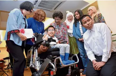  ??  ?? Light moment: Dr Siti Hasmah chatting with Branden Lim who has spinal muscular atropy at the cheque presentati­on ceremony by Global Doctors Malaysia in Kuala Lumpur. — Bernama