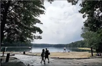  ?? CHARLES KRUPA — THE ASSOCIATED PRESS FILE ?? In this file photo, a couple walks along the shore of Walden Pond in Concord, Mass.