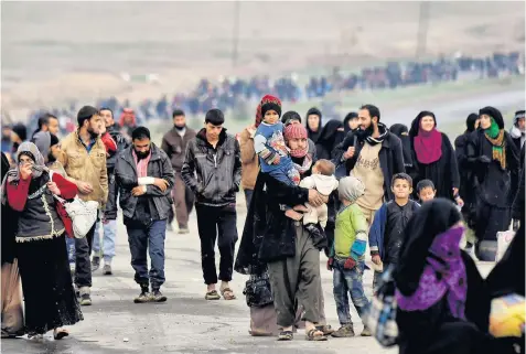  ??  ?? Iraqi families leave west Mosul after the army pushed deeper into Isil-held territory. Above right, a child receives treatment after a suspected chemical attack in the east of the city