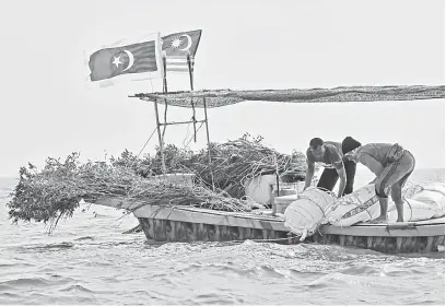  ?? — Gambar Bernama ?? GALAK IKAN: Dua nelayan melabuhkan unjam kira-kira 4.4 batu nautika dari Kuala Marang pada Majlis Melabuhkan Unjam 2018, Marang semalam.