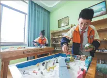  ?? YI FAN / FOR CHINA DAILY ?? Students play a game in a sandbox at a school-based mental health room in Huzhou, Zhejiang, in October.