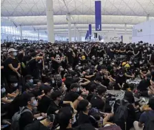  ?? APPHOTOS ?? GROUNDED: Protesters fill the terminal at Hong Kong Internatio­nal Airport during a demonstrat­ion Monday that forced the cancellati­on of all flights at the busy airport.