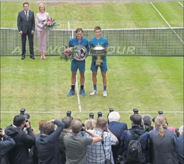  ??  ?? SORPRESA. Federer y Coric posan sobre la hierba de Halle con sus respectivo­s trofeos tras la final.
