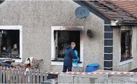  ??  ?? Gutted: Gardaí examine blaze house in west Dublin yesterday