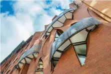  ??  ?? Creviced windows and lace-covered balconies interrupt the continuous brick surface and enable the townhouse occupants to engage with street life while retaining their privacy.