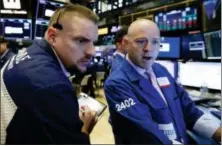  ?? RICHARD DREW — THE ASSOCIATED PRESS FILE ?? Trader Michael Milano, left, and specialist Jay Woods work on the floor of the New York Stock Exchange.