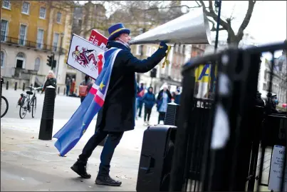  ?? The Associated Press ?? BREXIT: Anti-Brexit protester Steve Bray shouts through an over-sized loud hailer Thursday at the gates of Downing Street, London.