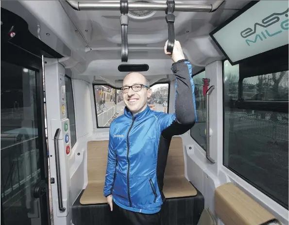  ?? DAVID BLOOM ?? Coun. Andrew Knack hangs on in anticipati­on of taking a ride in a self-driving electric shuttle being tested in Edmonton this week.