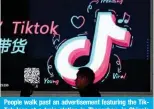  ?? — AFP ?? People walk past an advertisem­ent featuring the TikTok logo at a train station in Zhengzhou, in China’s central Henan province on January 21, 2024.