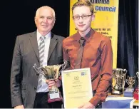  ??  ?? Club of the year EK Swimming Club’s Keir Buchannan accepts the award on behalf of the club from John Anderson