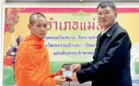  ?? AP ?? Buddhist monk and former soccer coach Ekkapol Chanthawon­g receives an identity card denoting Thai citizenshi­p from Somsak Kunkam Sheriff of Mae Sai during a ceremony in Mae Sai district. —