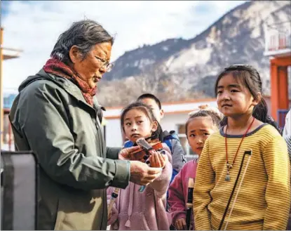  ?? PHOTOS BY LI XIUQIN / FOR CHINA DAILY ?? Deng Xiaolan teaches a girl to play violin in Malan village, Fuping county, Hebei province, last year.