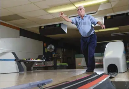  ??  ?? Ron Ferguson has a distinctiv­e style as he lobs the ball way before the foul line. Ferguson is 87 and has been bowling for 70 years, twice a week.