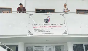  ?? ?? Election workers putting up the ‘Counting Station’ banner for the Sibu parliament­ary area, at the Islamic Complex.