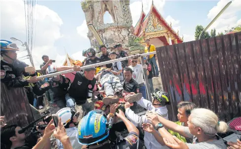  ?? PORNPROM SATRABHAYA ?? Rescue workers remove an injured person from the scene of a bell tower collapse at Wat Phraya Tham Voraviharn in Bangkok Noi district of Bangkok yesterday. Eleven workers were injured, two seriously.