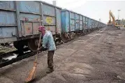  ?? [AP PHOTO] ?? Baburam sweeps domestical­ly produced petroleum coke to be transporte­d onto trucks hired by local factories in Rampur about 130 miles from New Delhi, India.