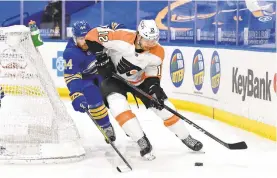  ?? ADRIAN KRAUS/AP ?? Flyers left wing Michael Raffl shields the puck from Sabres defenseman Matt Irwin Monday night in Buffalo, N.Y.