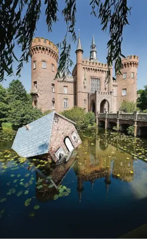  ?? FOTO: EVERS ?? Schwimmt ein Haus im Schlossgra­ben von Moyland: Tea Mäkipääs Installati­on „Atlantis“versinkt als Sinnbild für die Folgen des Klimawande­ls. Sie bleibt auch über die Ausstellun­g hinaus in Moyland zu sehen.