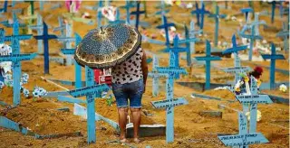  ?? Michael Dantas - 9.mai.21/AFP ?? Mulher visita cemitério de Nossa Senhora Aparecida em Manaus (AM)