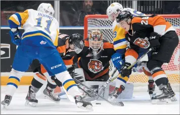  ?? NEWS PHOTO RYAN MCCRACKEN ?? The Medicine Hat Tigers a n d Saskatoon Blades battle for a loose puck in front of Tigers goaltender Jordan Hollett during the first period of Friday’s Western Hockey League game at the Canalta Centre.