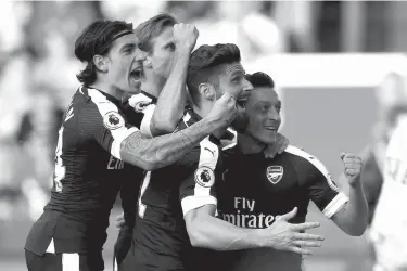  ?? Associated Press ?? Arsenal's Mesut Ozil, right, celebrates scoring his side's second goal of the game with teammates during their English Premier League soccer match Saturday against Stoke City at the bet365 Stadium, Stoke-on-Trent, England.