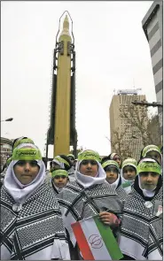  ?? AP/VAHID SALEMI ?? A surface-to-air missile looms over Iranian children outside the former U.S. Embassy on Saturday in Tehran during an annual celebratio­n of the 1979 takeover of the embassy by revolution­ary forces.