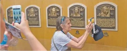  ?? MIKE GROLL/ASSOCIATED PRESS FILE PHOTOS ?? Fans visit the Plaque Gallery in 2015 at the National Baseball Hall of Fame in Cooperstow­n, N.Y. This weekend brings the latest crop of inductees into the Baseball Hall of Fame — Vladimir Guerrero, Chipper Jones, Jack Morris, Alan Trammell, Jim Thome and Trevor Hoffman.