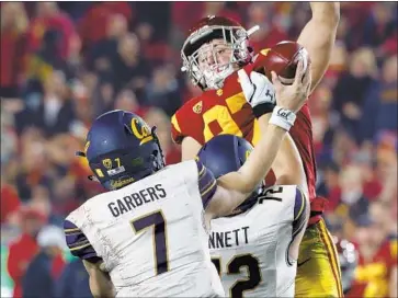  ?? Luis Sinco Los Angeles Times ?? THE TROJANS’ Jacob Lichtenste­in jumps up to block a pass by California’s Chase Garbers in the second quarter. Garbers had only 93 yards passing and the Golden Bears were held to 200 total yards.