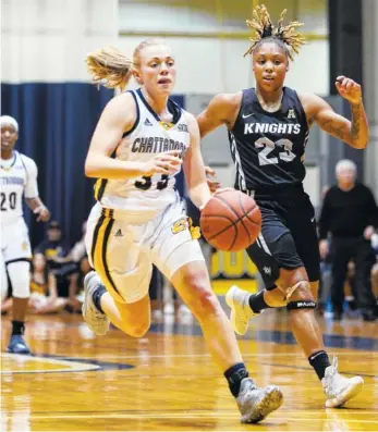  ?? STAFF PHOTO BY ERIN O. SMITH ?? UTC guard Lakelyn Bouldin, left, dribbles the ball downcourt as Central Florida’s Lawriell Wilson trails during Monday’s game at Maclellan Gym. The Mocs fell to the Knights 58-57.