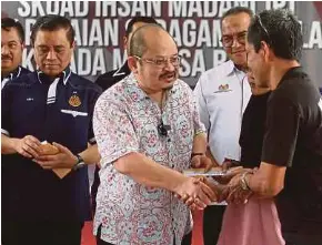  ?? NSTP PIC BY NIK ABDULLAH NIK OMAR ?? The prime minister’s senior political secretary, Datuk Seri Shamsul Iskandar Mohd Akin, presenting aid to a flood victim at the Kelantan Road Transport Department’s Madani Ihsan Squad assistance ceremony in Tanah Merah yesterday.