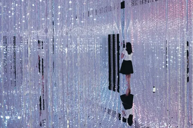  ?? TOMOHIRO OHSUMI/GETTY LLUÍS GENÉ / AFP / GETTY ?? ‘Wander through the Crystal Universe’, una instalació­n digital del colectivo de artistas japonés teamLab en una exposición en Tokio en agosto del 2016 A la derecha, un hombre probando un artefacto de realidad virtual en el Mobile World Congress de...