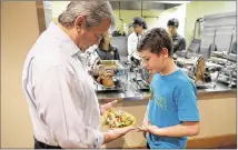  ?? RICARDO B. BRAZZIELL / AMERICAN-STATESMAN ?? Austin Mayor Steve Adler talks to Ian McKenna, 12, last month at El Buen Samaritano. Ian started an organizati­on that builds gardens to grow produce for the needy.