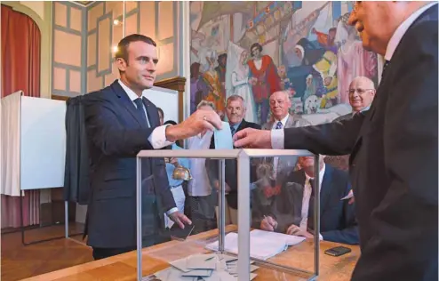  ?? CHRISTOPHE ARCHAMBAUL­T AGENCE FRANCE-PRESSE ?? Le président français, Emmanuel Macron, a voté au Touquet dimanche, dans le nord du pays. Avec plus de 300 sièges, il pourra gouverner sans même faire de compromis avec le parti de son allié François Bayrou.