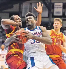  ?? Ed Zurga Getty Images ?? UDOKA AZUBUIKE muscles his way to the basket past two Iowa State defenders in the Kansas win. The Jayhawks now rest prior to Saturday’s game at Baylor.