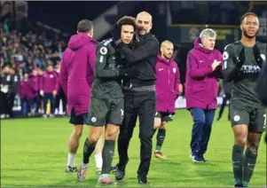  ?? OLI SCARFF/AFP ?? Manchester City’s German midfielder Leroy Sane (second left) is embraced by Manchester City’s Spanish manager Pep Guardiola after the English Premier League match between Huddersfie­ld Town and Manchester City on Sunday.