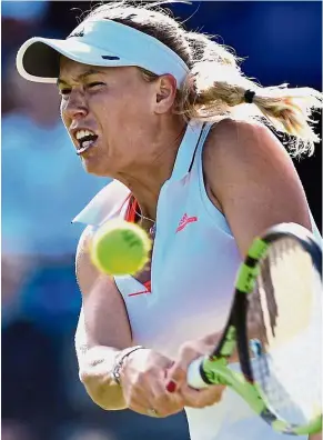  ?? – AFP ?? Firing guns: Denmark’s Caroline Wozniacki returns a shot to Romania’s Simona Halep during their quarter-final match at the Aegon Internatio­nal in Eastbourne on Thursday.