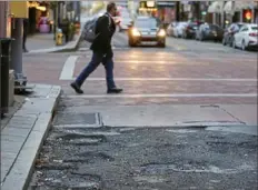  ??  ?? Potholes line a corner along Sixth Street, Downtown, on Wednesday.