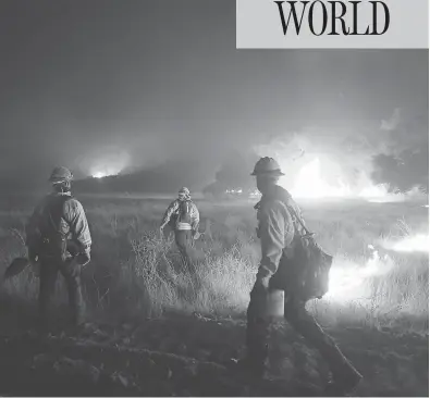  ?? MARK RALSTON / AFP / GETTY IMAGES ?? Fire crews work to contain the destructiv­e wildfire that continues to burn in Southern California.