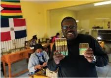  ??  ?? Mafundikwa poses for pictures with his company’s hand rolled cigars as he poses for a portrait at his factory in Harare.