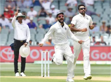  ??  ?? Virat Kohli and Ravichandr­an Ashwin celebrate Marcus Harris’ wicket in Adelaide yesterday. At bottom, Travis Head celebrates reaching his half-century.