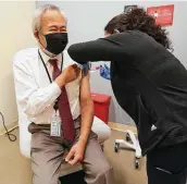  ?? Karen Warren / Staff photograph­er ?? Dr. Michael Lee gets his Pfizer COVID-19 vaccine booster shot Friday at Baylor College of Medicine.