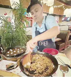  ?? ?? Tomatito founder chef Willy Trullas Moreno prepares paella tableside for the guests at the new branch in Estancia, Pasig City.