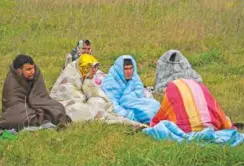  ?? ?? Rescued migrants sit covered in blankets Sunday at a beach near Cutro, southern Italy. Rescue officials say an undetermin­ed number of migrants died and dozens were rescued after their boat broke apart off southern Italy.