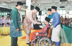  ?? — Gambar Bernama ?? TERIMALAH: Sultan Nazrin (dua kiri) berkenan menyampaik­an Anugerah Mursyid Masjid Sultan Idris Shah II kepada Datuk Sheikh Muhammad Nor Mansor (berkerusi roda) pada Majlis Sambutan Jubli Emas Masjid Sultan Idris Shah ll yang juga dikenali sebagai Masjid negeri di Ipoh, semalam.