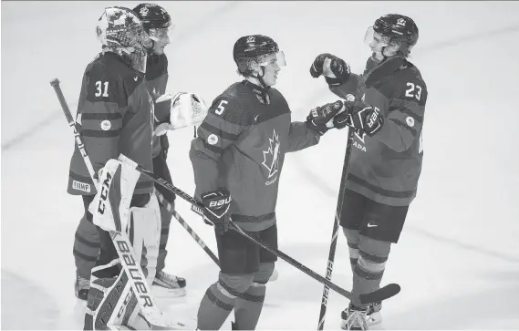  ?? GEOFF ROBINS/THE CANADIAN PRESS ?? Team Canada goalie Carter Hart, from left, Victor Mete, Josh Mahura and Sam Steel hope to be doing more celebratin­g of the gold medal variety.