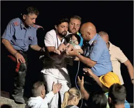  ??  ?? ANSA / via AP
Rescuers pull out 7-month-old boy Pasquale from the rubble of a collapsed building in Casamiccio­la, on the island of Ischia, near Naples, Italy, a day after a 4.0-magnitude quake.