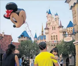  ?? Kin Cheung Associated Press ?? VISITORS to Hong Kong Disneyland in 2015. Visits from internatio­nal tourists rose last year, but the resort reported a big attendance drop from mainland China.