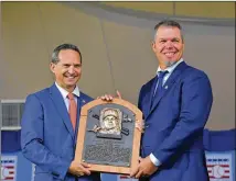  ?? HYOSUB SHIN / HSHIN@AJC.COM ?? Chipper Jones and Jeff Idelson, president of the National Baseball Hall of Fame and Museum, display the Braves legend’s Hall of Fame plaque during Sunday’s ceremony.