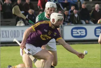  ??  ?? Cathal Dunbar stoops to win the ball ahead of Offaly defender Paddy Delaney.